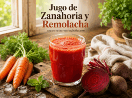 Jugo de zanahoria y Remolacha (betabel) para limpiar el organismo Vaso de jugo de zanahoria y betabel casero recién preparado, con zanahorias y betabel frescos alrededor