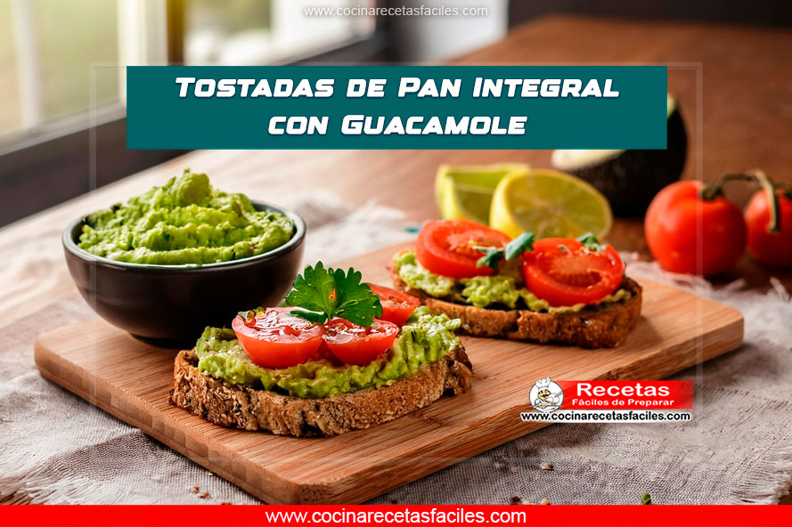 Tostada de pan integral con guacamole decorada con cilantro y tomate.