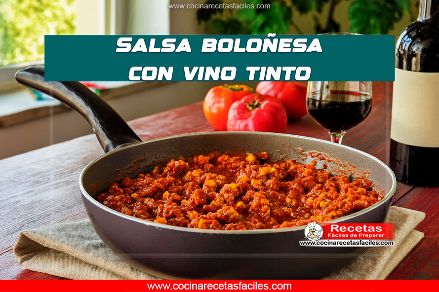 Salsa boloñesa con vino tinto en sartén sobre mesa de madera