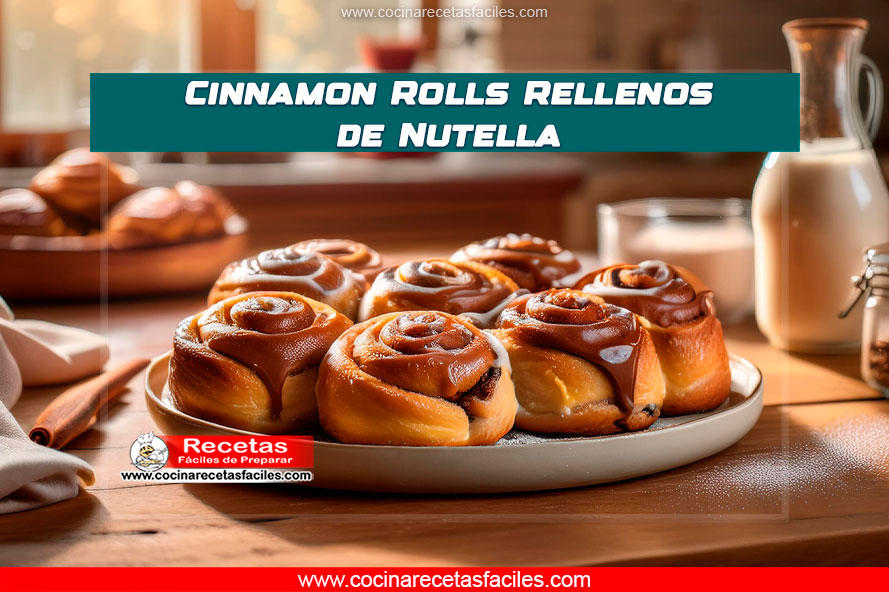 "Cinnamon rolls rellenos de Nutella con glaseado de azúcar glas sobre una mesa de cocina."