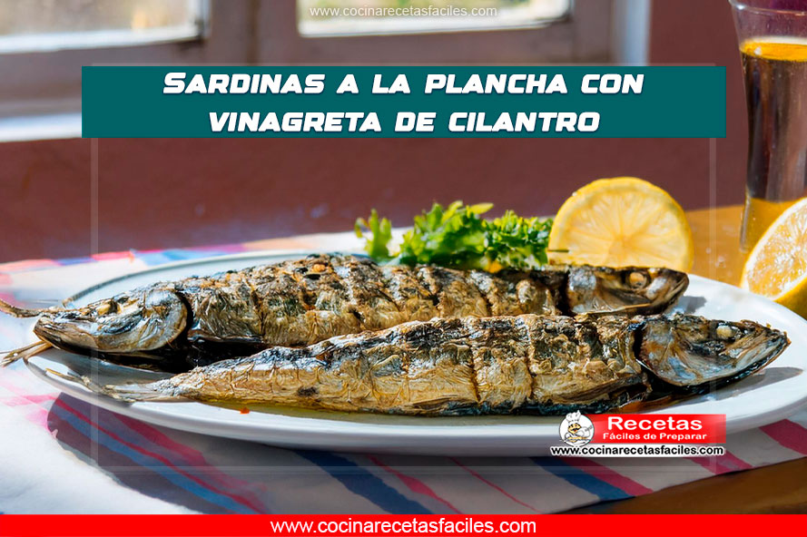 "Sardinas doradas a la plancha con vinagreta de cilantro fresca, decoradas con cilantro y limón."