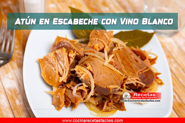 Atún en escabeche con cebolla y pimentón, servido en plato blanco sobre mesa de madera