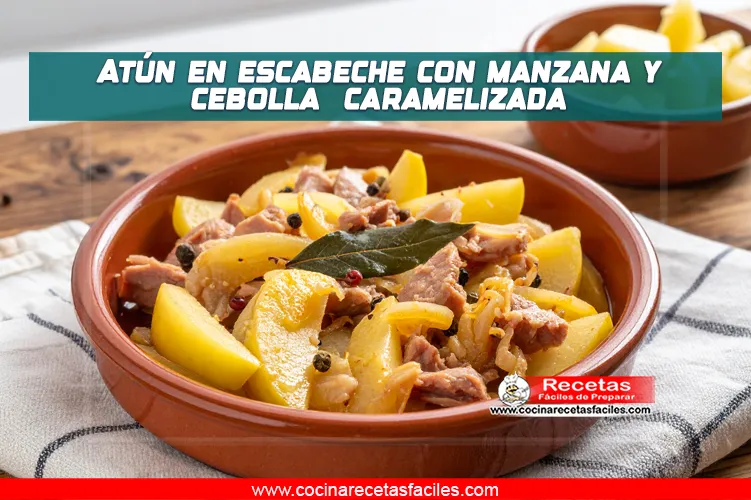 Atún en escabeche con rodajas de manzana y cebolla caramelizada servido en plato rústico con laurel y granos de pimienta.