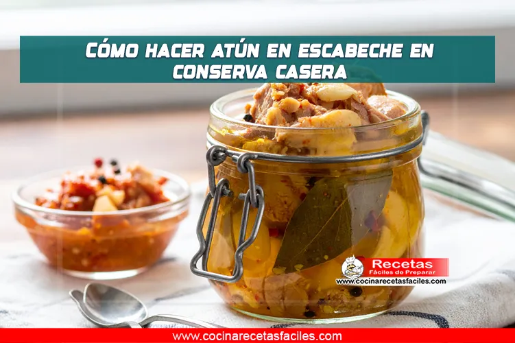 Frascos de conserva con atún en escabeche casero, acompañados de laurel, ajo y pimienta en grano.