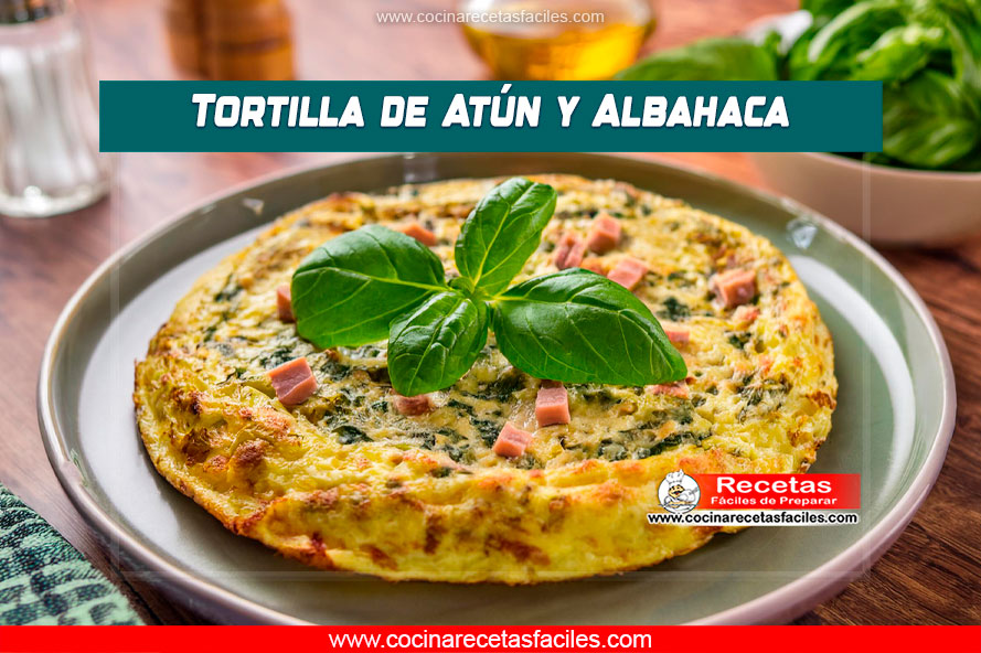 Tortilla de atún y albahaca cocida con todos los ingredientes integrados, servida en un plato sobre una mesa de madera, en una cocina con ventana grande.