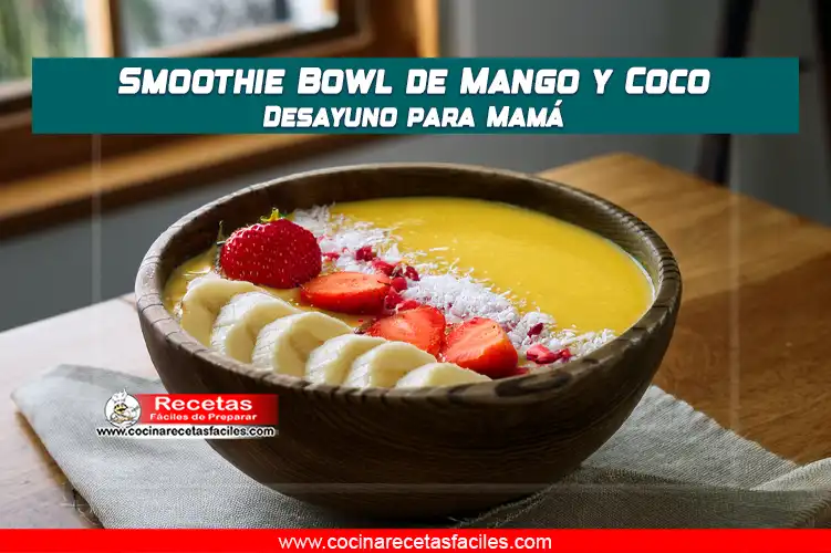 "Smoothie bowl de mango y coco con base cremosa amarilla, decorado ligeramente con rodajas de plĂĄtano, fresas, coco rallado y granola."