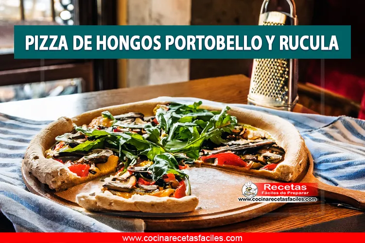 Pizza de hongos portobello y rúcula servida sobre una mesa rústica con luz natural entrando por una ventana.