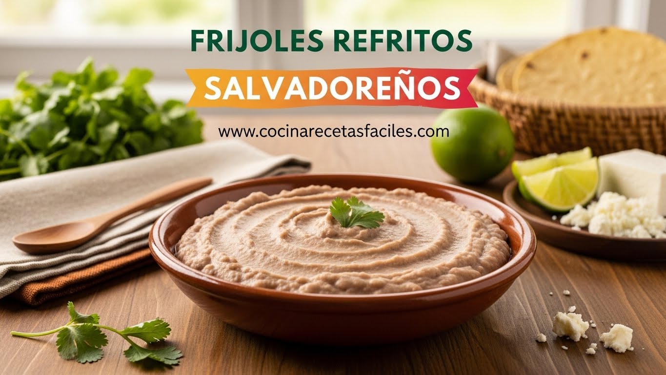 Plato hondo de cerámica con frijoles refritos salvadoreños de textura completamente cremosa y licuada sobre mesa de madera, acompañado de tortillas y queso fresco